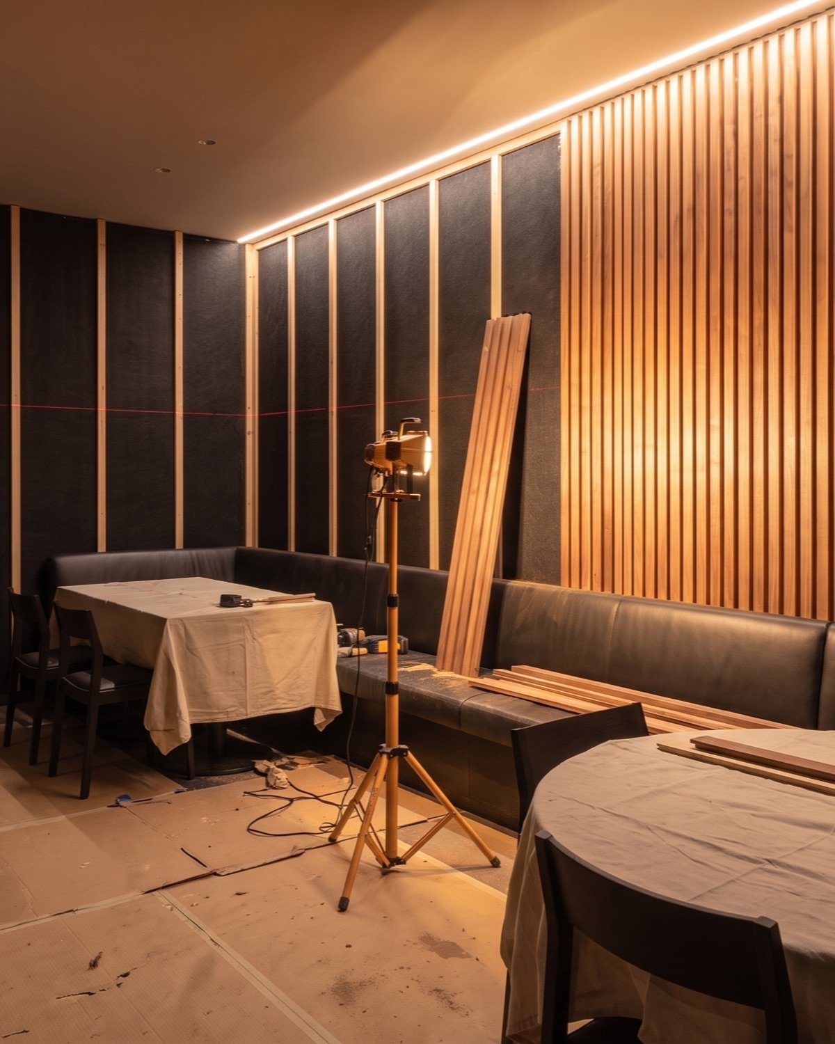 Walnut slats being installed on a restaurant wall
