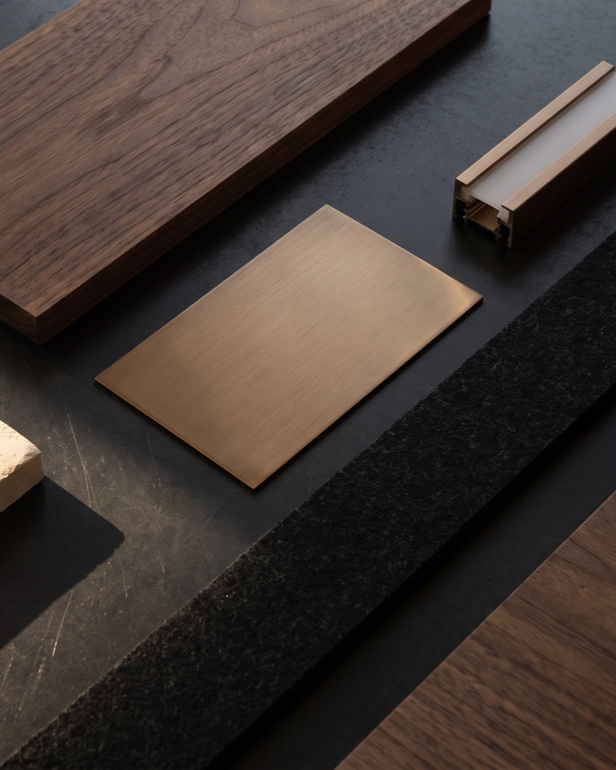 Walnut, plaster, bronze and felt samples on a black table